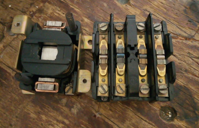 Слева,виден магнитопровод с надетой на среднюю часть катушкой, а справа - контактная группа с зажимами под провода.