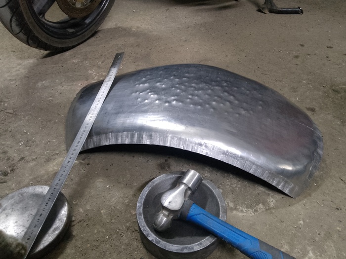 Покатав на английском колесе и покусав лист шринкером принялся формировать верхний радиус крыла ударами молотка. На фото их пока мало.После примерно500-1000 ударов вручную 800граммовым молотком рука начинает отваливаться.Но никто не говорил что будет легко