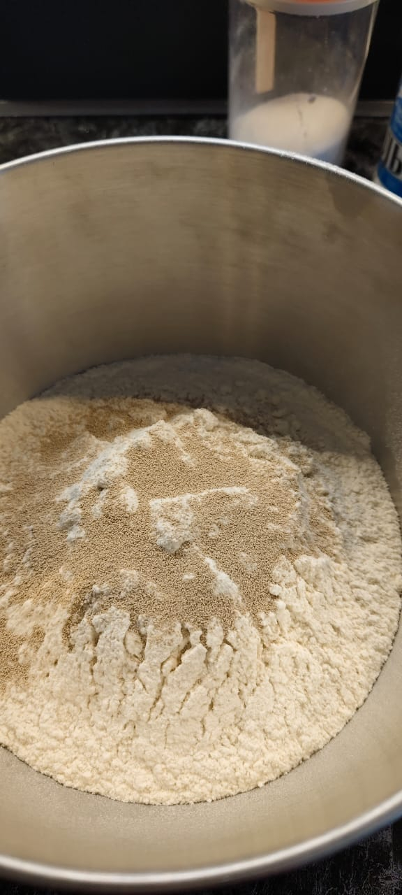 Добавляю к муке сухие дрожжи, сахар и соль.