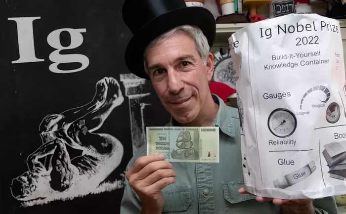 Церемониймейстер и создатель Шнобелевской премии Марк Абрахамс позирует с призом в 10 триллионов зимбабвийских долларов