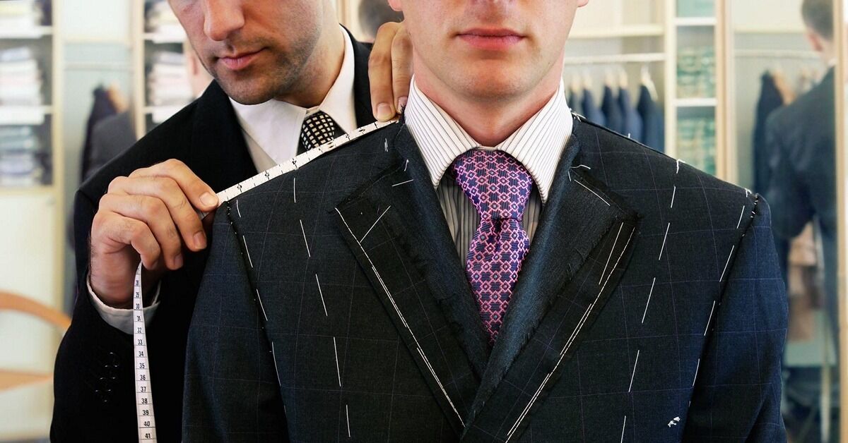 мужчина у портного на примерке костюма