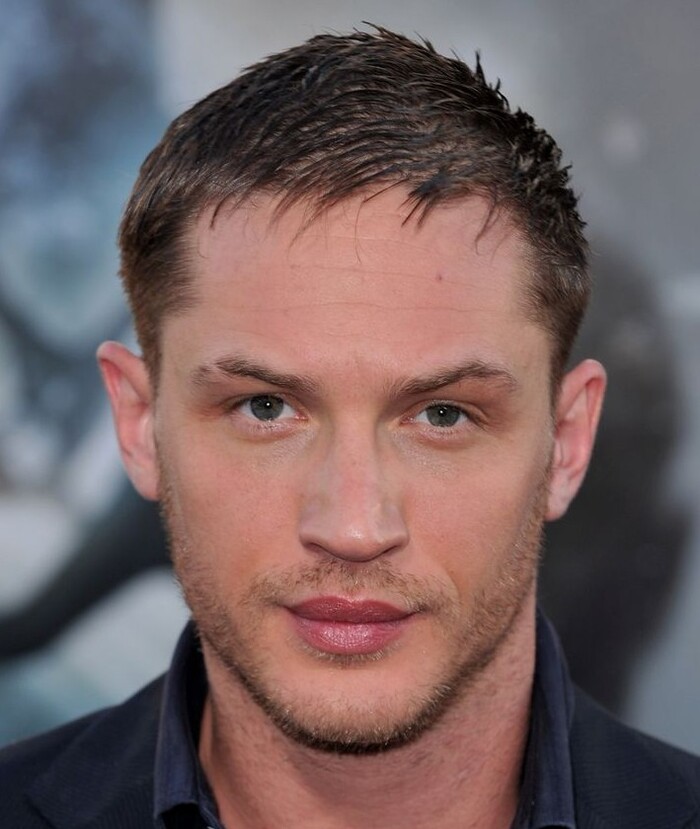 Средняя симметрия, сильная челюсть, черты близки к усреднённым, с отклонениями от идеальных пропорций: неравные трети лица, средние глаза и нос, гладкая кожа без экстрем.