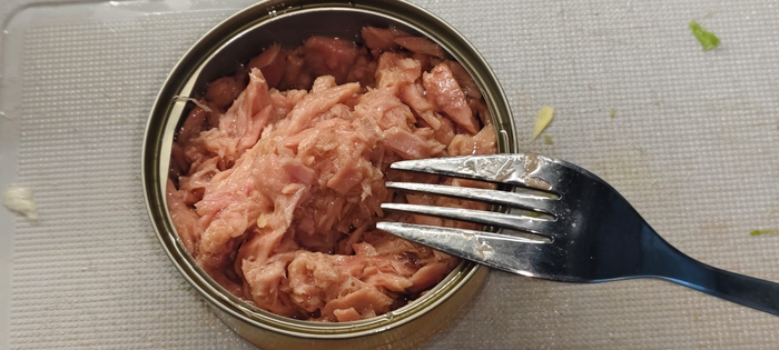 Сливаю масло с тунца. Оно не понадобится. Разминаю вилкой