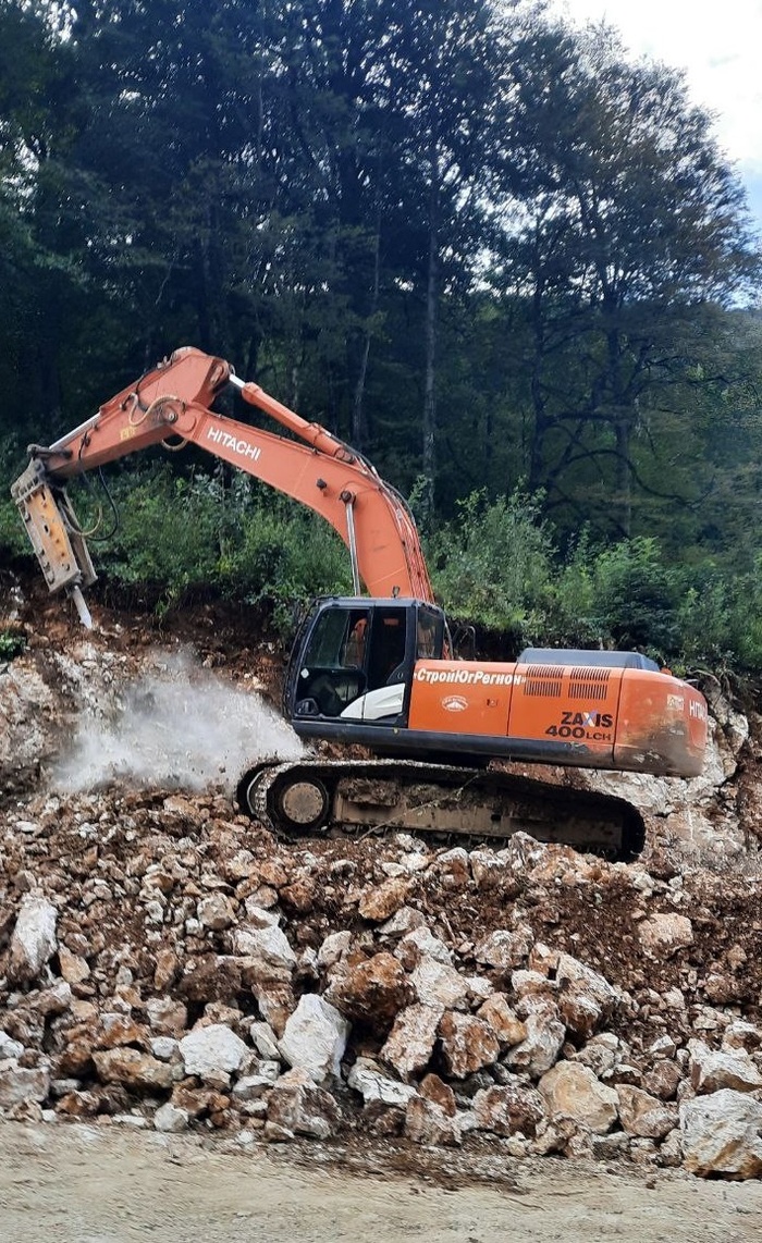 экскаватор колет скалы