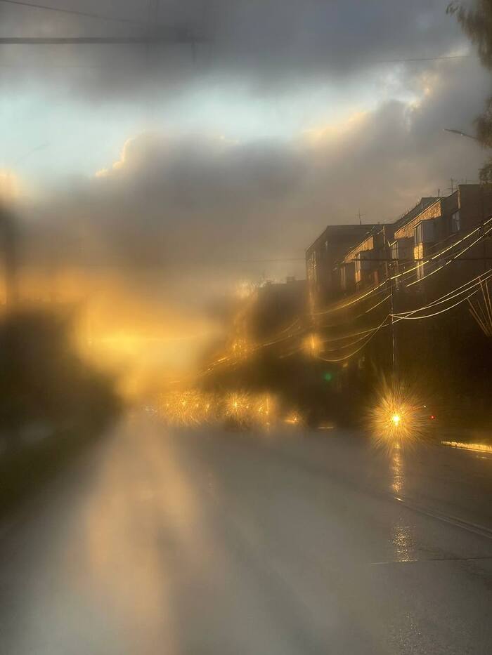 Закат в городе через окно троллейбуса