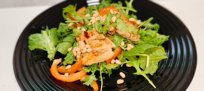 На подушку из салата выкладываю грудку. Украшаю листочками кинзы, кедровыми орешками. Поливаю соусом. Это вкусно и полезно!