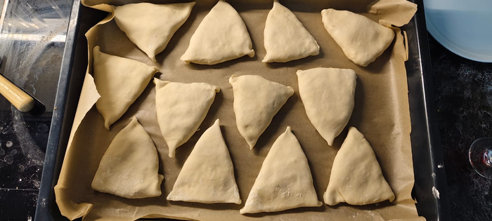 Выкладываю самсу на противень застеленный пергаментом. Получились не равнобедренные треугольники :)