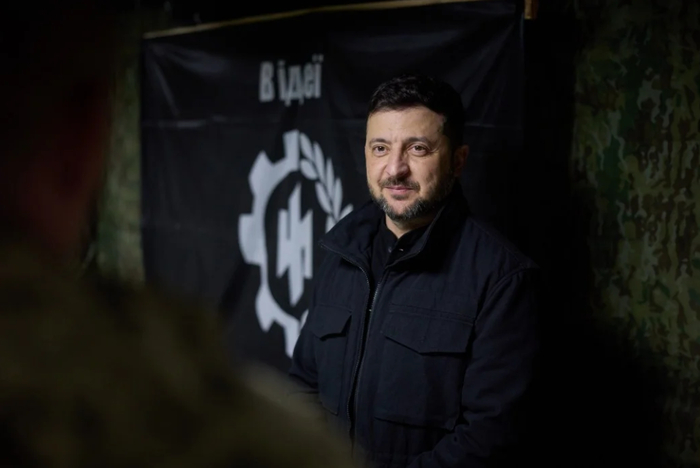 Не монтаж. Еврейский президент Зеленский во время посещения добровольческих подразделений на Донецком фронте 4.11.2025 на фоне нацистского символа бригады «Рубеж».