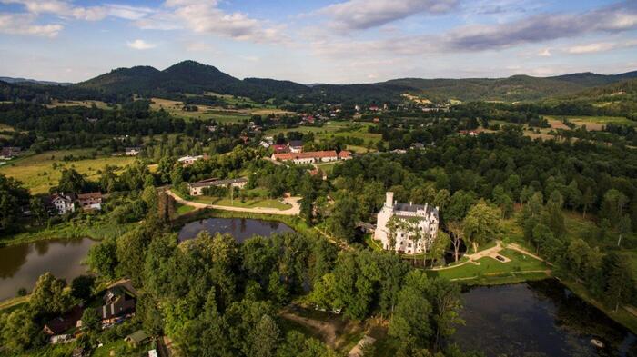 На юго-западной окраине обширного поселка Карпники (ранее Фишбах) в Рудавий-Яновицком воеводстве, у подножия живописных горных хребтов Соколе, в районе культурного парка «Долина дворцов и садов» в долине Еленя-Гура, находится очень интересный замок.