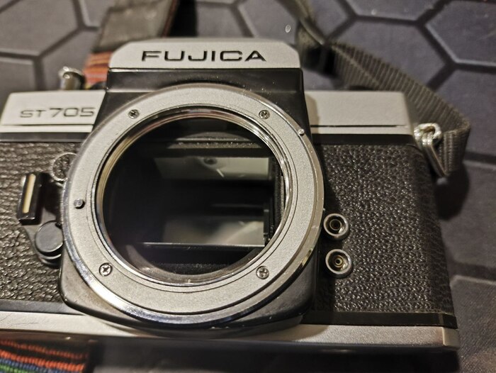 В правом верхнем углу кольца посадочного кольца объектива видно штифт который заходит в ответное кольцо на объективе и контролирует значение диафрагмы